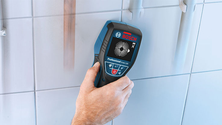 Un dispositivo de localización profesional de Bosch se sostiene cerca de los azulejos.