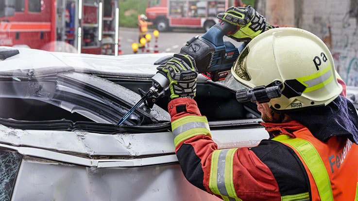 Пожарный в защитной одежде использует аккумуляторный резак Bosch.