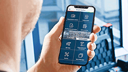 A person is holding a smartphone with the Bosch Professional app in hand.