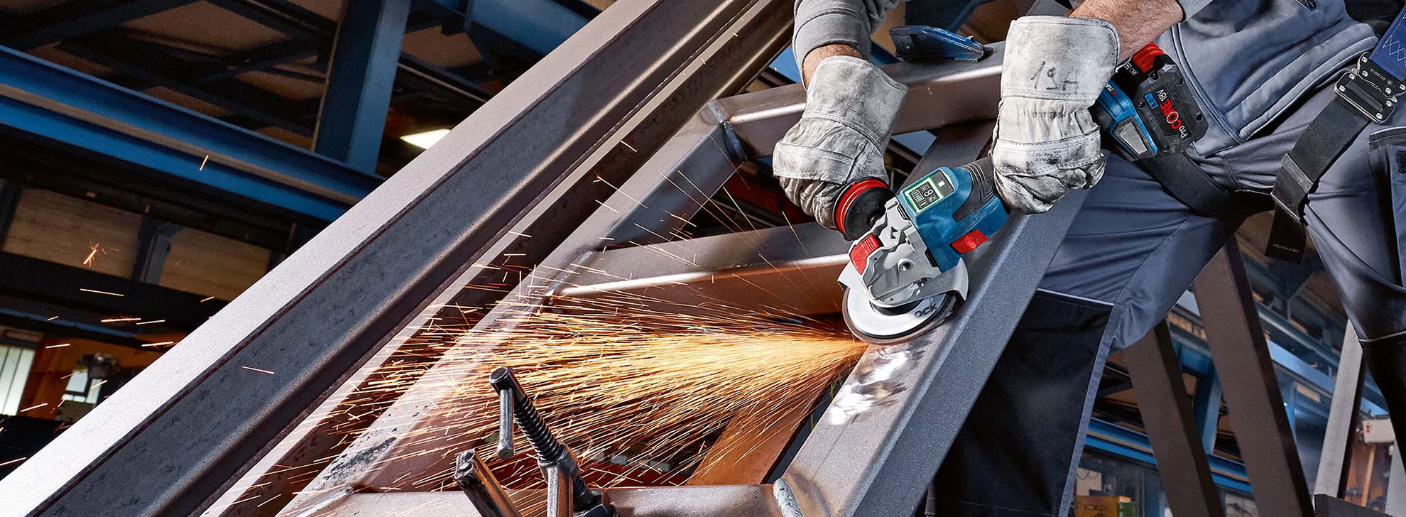 Ремесленник использует угловую шлифовальную машину Bosch Professional, искры летят.