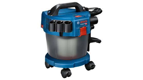 Modrý vysavač Bosch Professional stojí na kolech, s příslušenstvím.