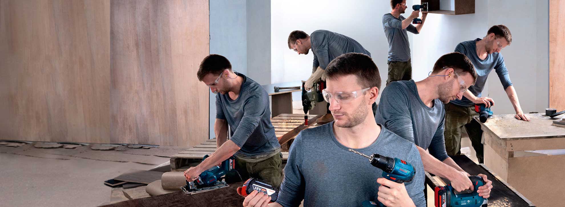 Мужчина с инструментами Bosch работает над деревянной поверхностью в мастерской.