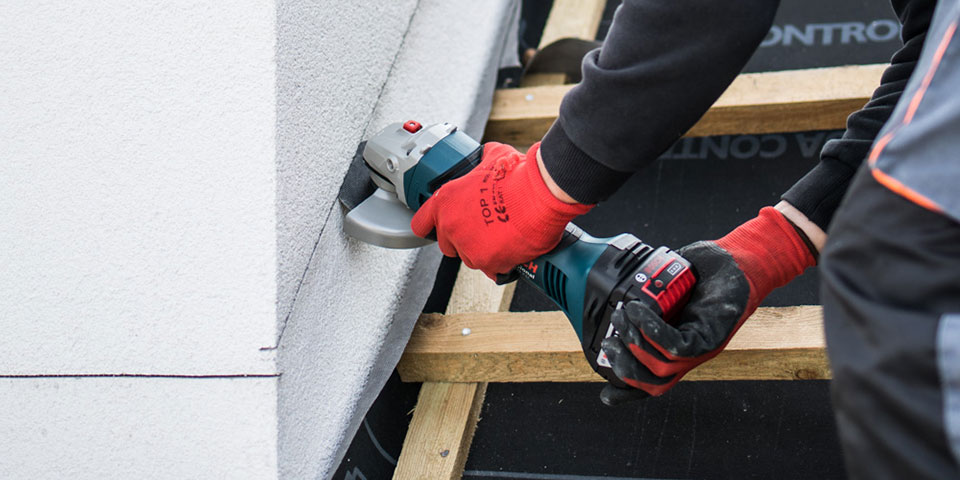 Osoba tnie narzędziem Bosch Professional na ścianie.