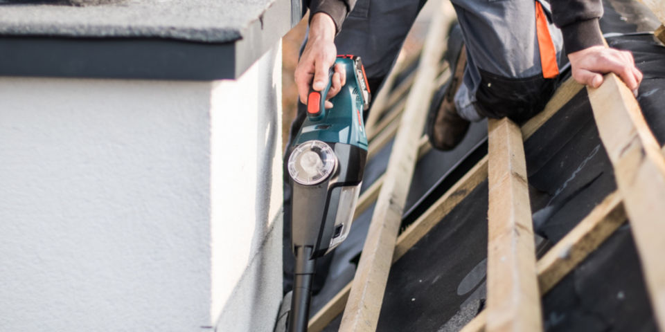 Rzemieślnik używa akumulatorowej piły jigsaw Bosch Professional na dachu.