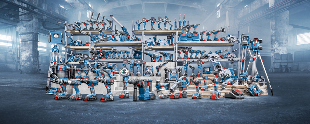 Various blue Bosch Professional tools on shelves in a workshop.