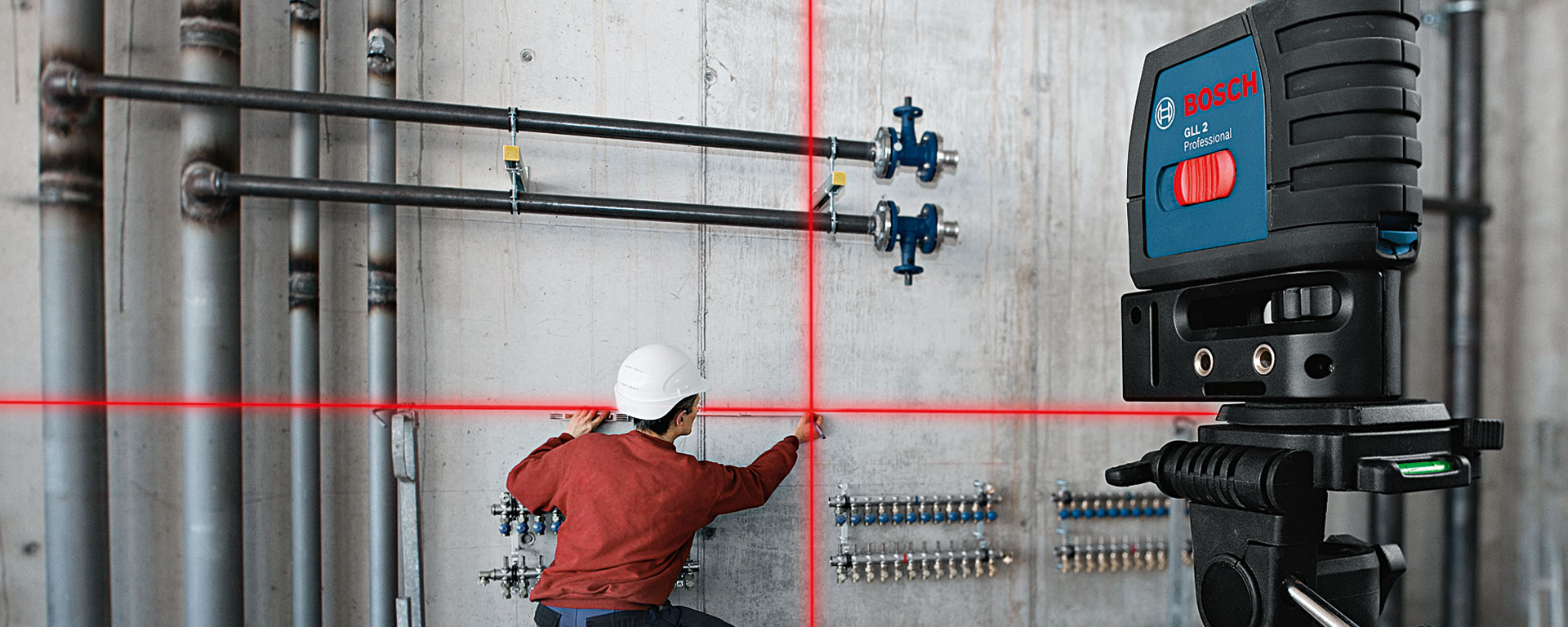 Um laser de linha Bosch Professional brilha em uma parede, um trabalhador mede.