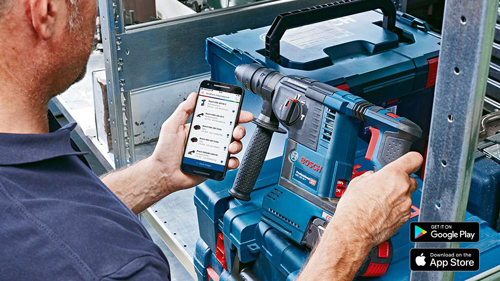 Un uomo tiene uno smartphone e utilizza un trapano Bosch Professional.