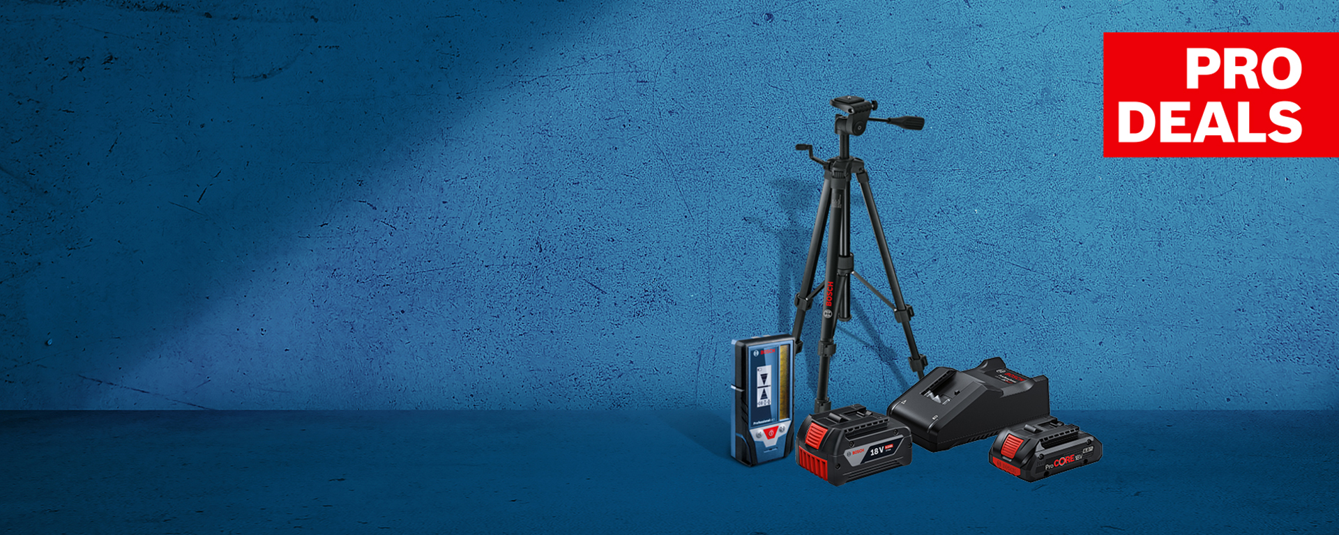 Черна стойка стои пред синя стена, до нея има инструменти и батерии.