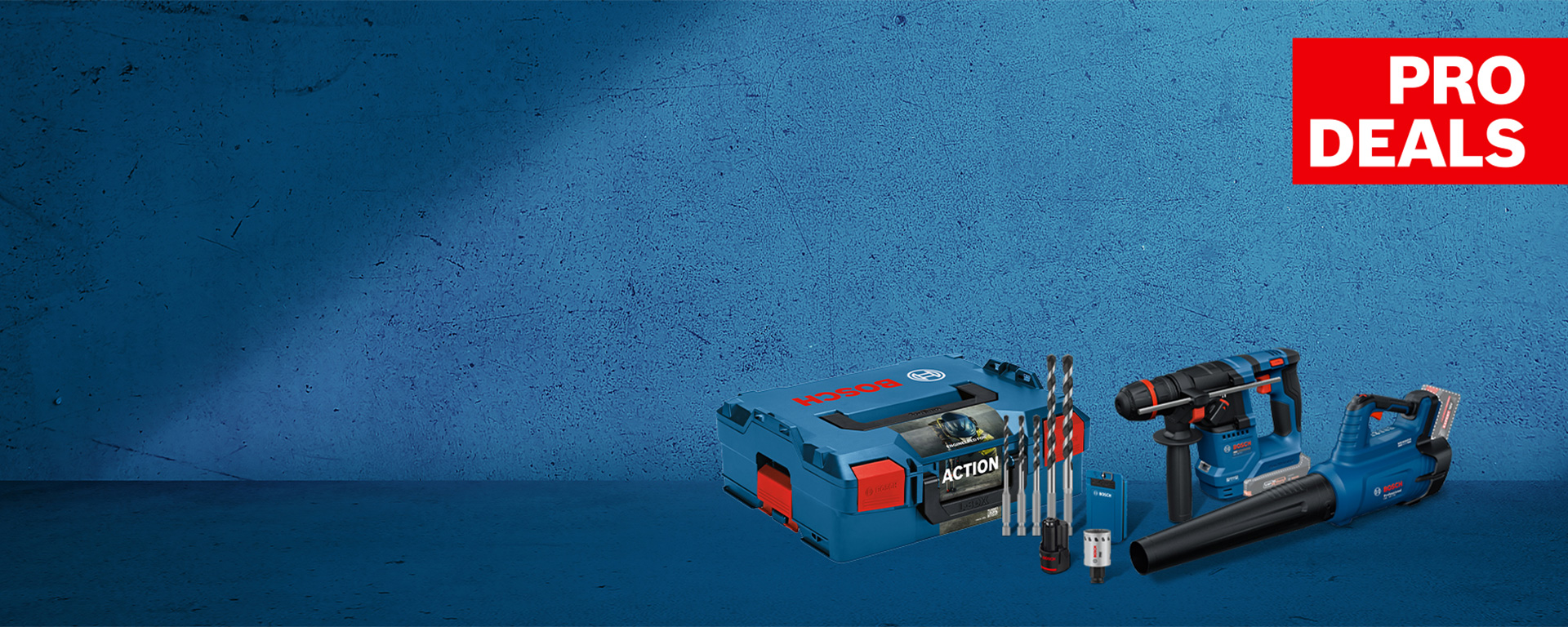 A Bosch Professional tool set on a blue surface, consisting of a cordless screwdriver, a blower, drills, and a toolbox.
