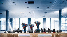 Bosch professionella verktyg på en trähylla på en ljus byggarbetsplats.