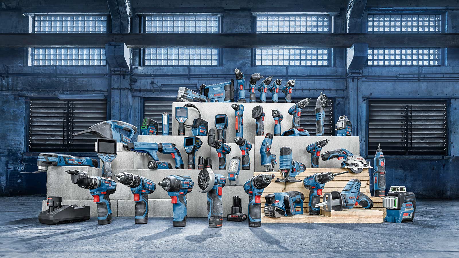 Diverse Bosch Professional tools on wooden pallets in a hall.