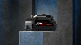 Una herramienta negra sobre una superficie gris, rodeada de paredes azules y grises.