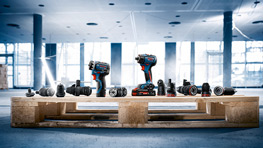 Una paleta de madera sostiene varias herramientas eléctricas en un entorno moderno y luminoso.