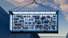 Un contenedor colgante con diversas herramientas, iluminado frente a un cielo nocturno.