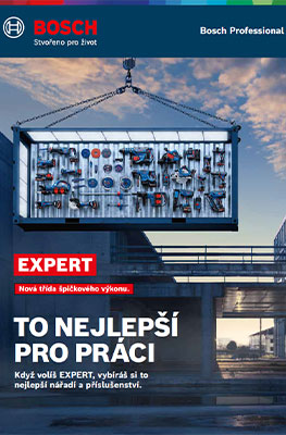 Velká šedá toolbox visí na jeřábu nad staveništěm, viditelná s mnoha nástroji.