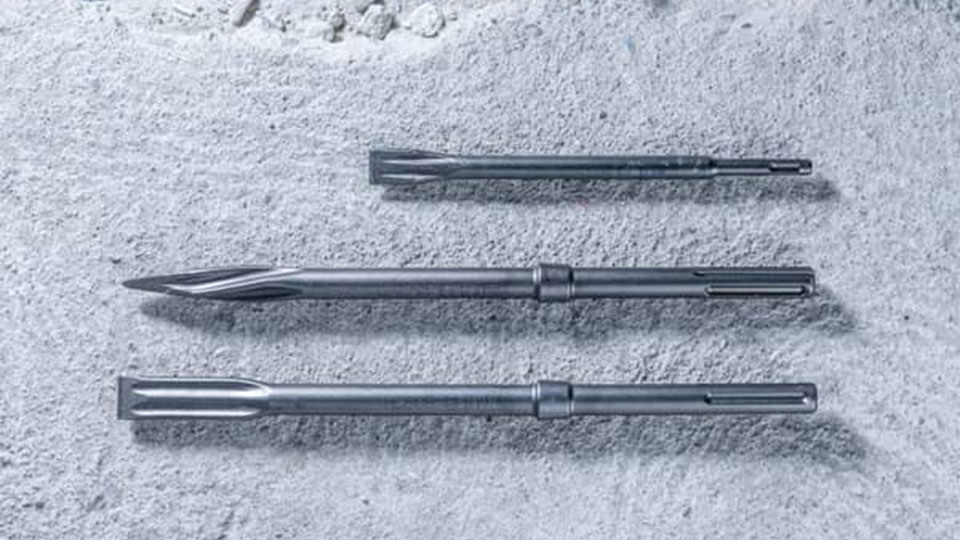 Tre accessori per strumenti Bosch Professional grigi sono posati su un pavimento in cemento.