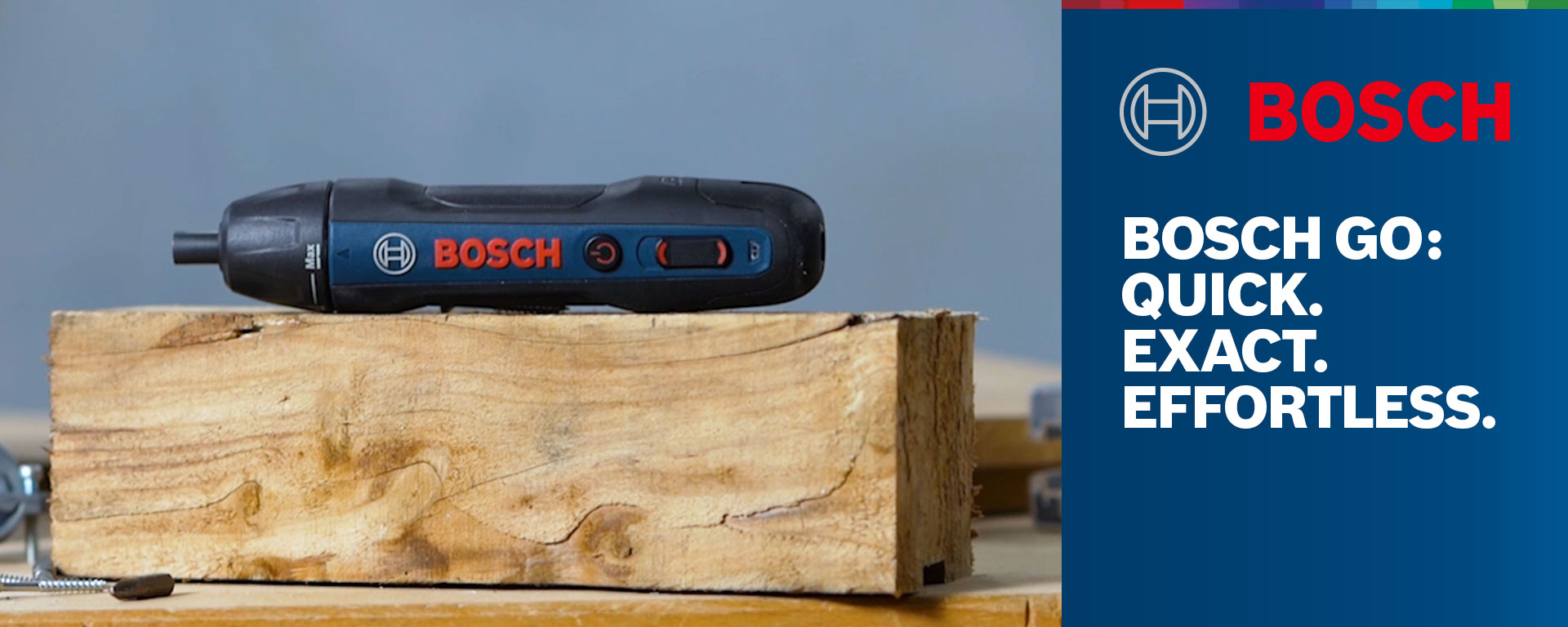 A black Bosch Professional cordless screwdriver is lying on a wooden block.