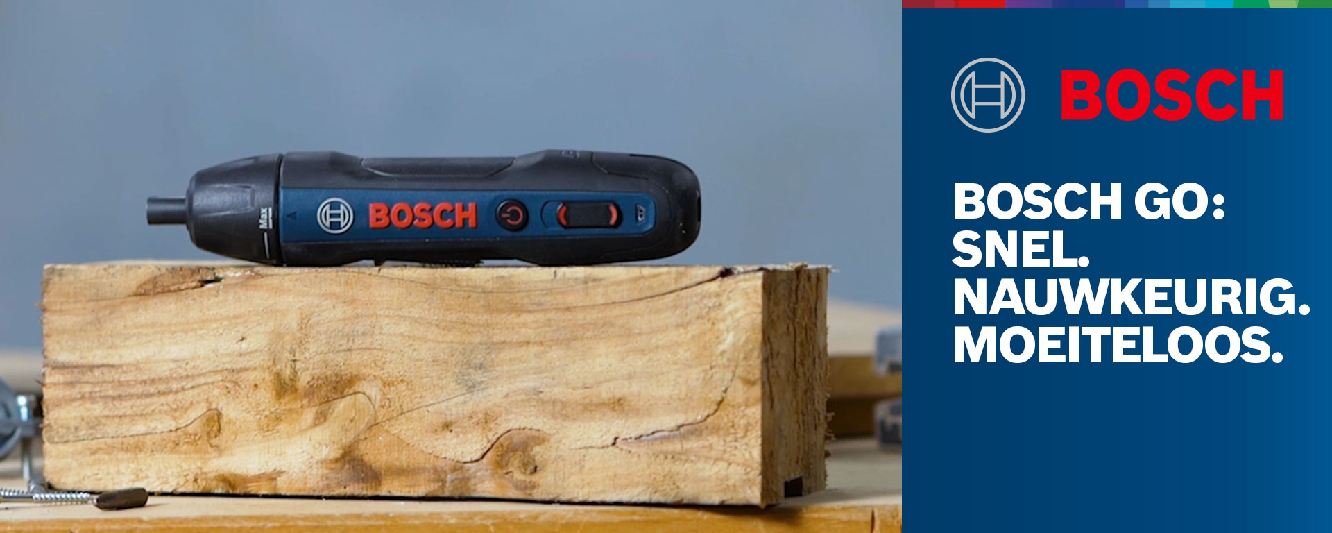 Zwarte Bosch GO schroevendraaier op houten blok, achtergrond onscherp.