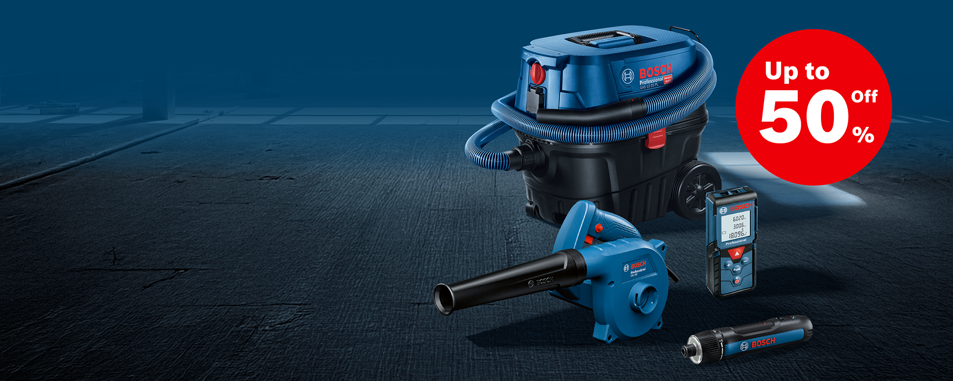 A blue Bosch Professional vacuum cleaner stands on a dark background, next to a blower, a measuring device, and a flashlight. In the background, a discount banner of up to 50%.