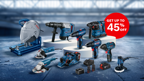 An arrangement of Bosch Professional tools on white pedestals, including a circular saw, hammer drill, cordless screwdriver, angle grinder, and accessories. In the background, a blurred industrial scene. A red banner with "GET UP TO 45% OFF" in the upper right corner.
