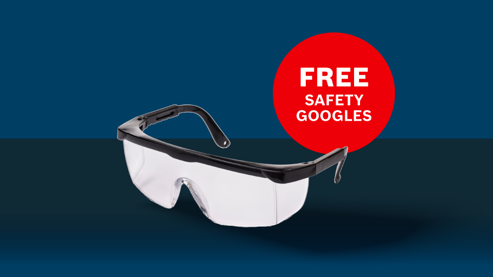 A pair of transparent safety goggles with a black frame on a blue background, next to a red circle with the text "FREE SAFETY GOGGLES".