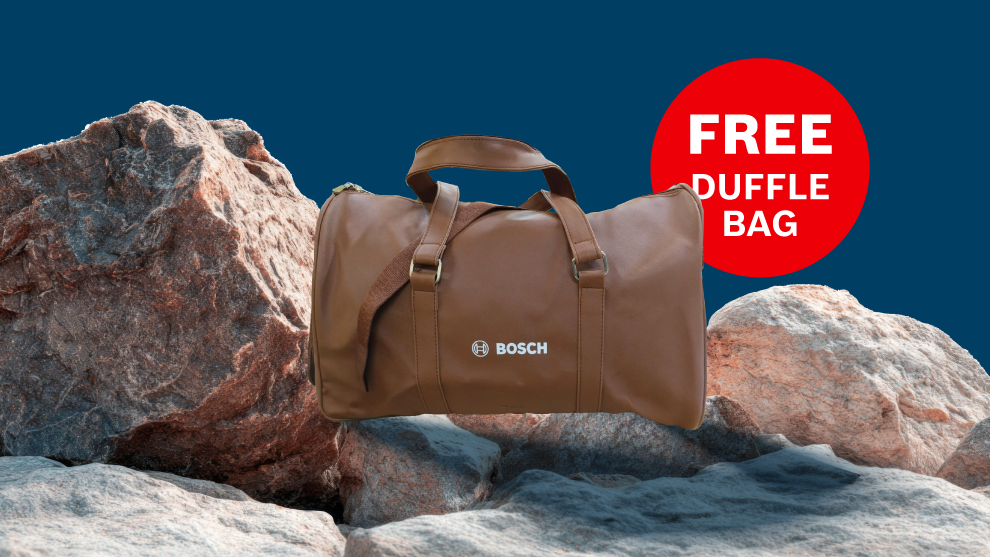 A brown Bosch bag lies on gray rocks against a blue background with the text "FREE DUFFLE BAG".
