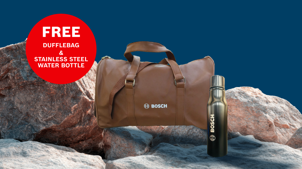 A brown sports bag with the Bosch logo stands on gray stones next to a black stainless steel water bottle.