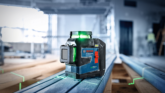A Bosch Professional line laser stands on blue metal profiles on a scaffolding, with green lines.