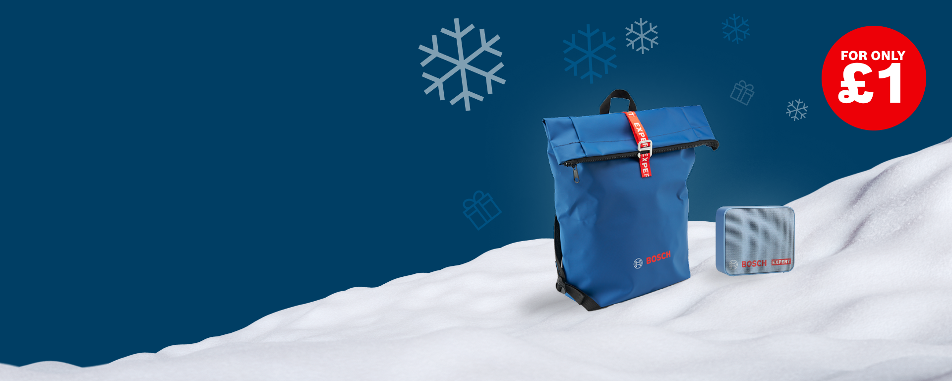 A blue backpack and a Bluetooth speaker are placed on a snow-covered surface against a dark blue background. In the background, white snowflakes and Christmas gifts are depicted. A red price tag reads "FOR ONLY £1".
