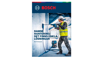 En hantverkare i gul väst använder en Bosch-borr i ett rum.