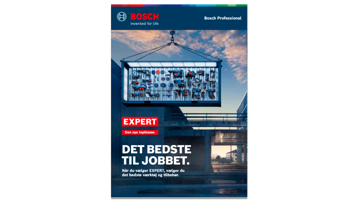 En stor værktøjskasse fra Bosch Professional hænger i en kran over en byggeplads, med værktøjer synlige.