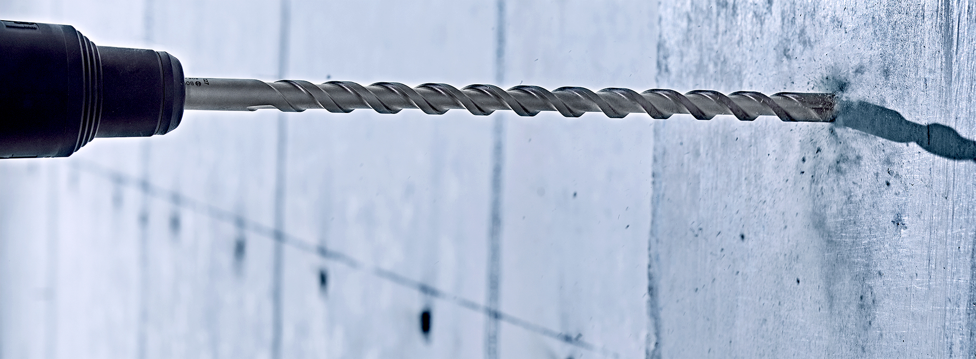 مثقاب بوش الاحترافي يثقب في جدار رمادي.