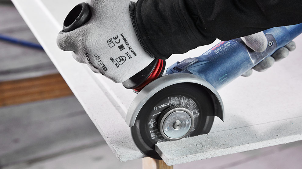 A Bosch Professional angle grinder is cutting a plate.