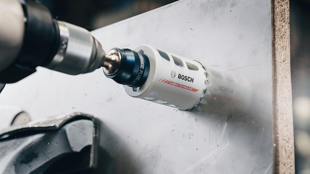 Un trapano professionale Bosch sta forando un pezzo di metallo.