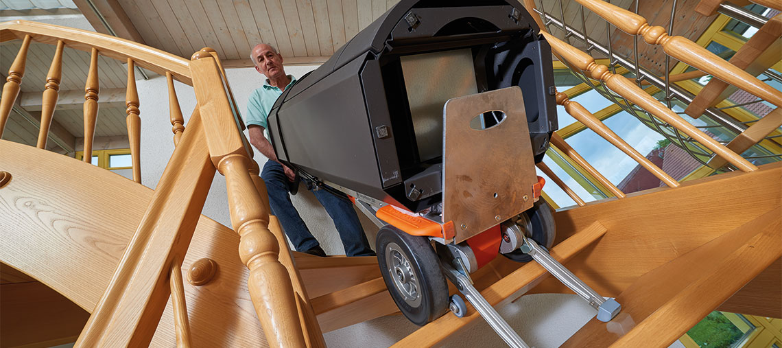 Muž nese černou toolbox po schodech.