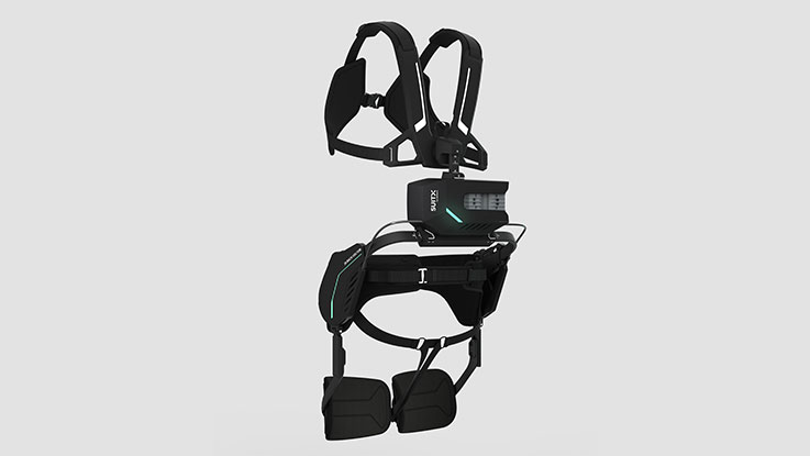 Černý exoskelet se zelenými akcenty na šedém pozadí.