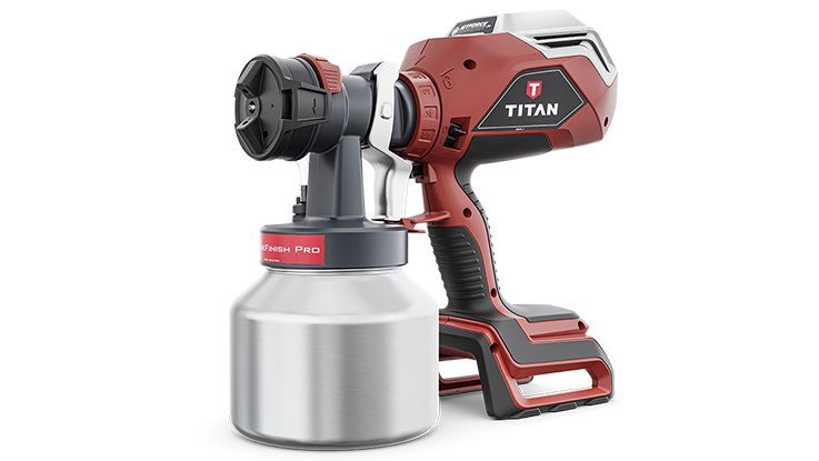 Červené zařízení na sprej Titan stojí vedle stříbrné nádoby na barvu.