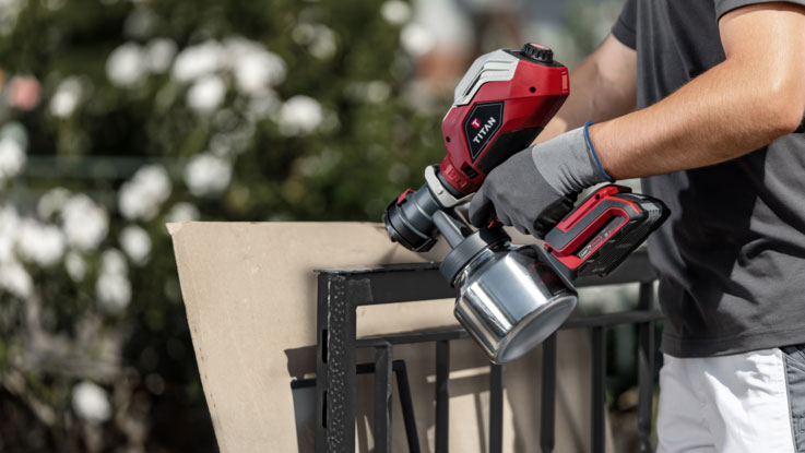 Červený profesionální stříkací přístroj Bosch je držen u zdi.