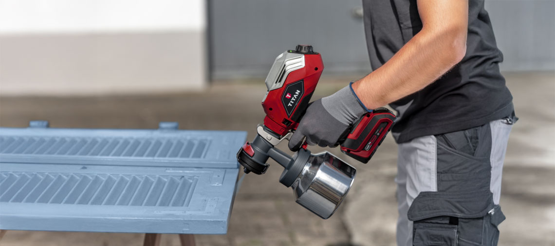 Červené zařízení na stříkání barvy Titan je používáno osobou.