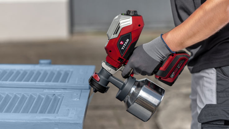 Červené zařízení na sprejování TITAN se používá na modrém povrchu.