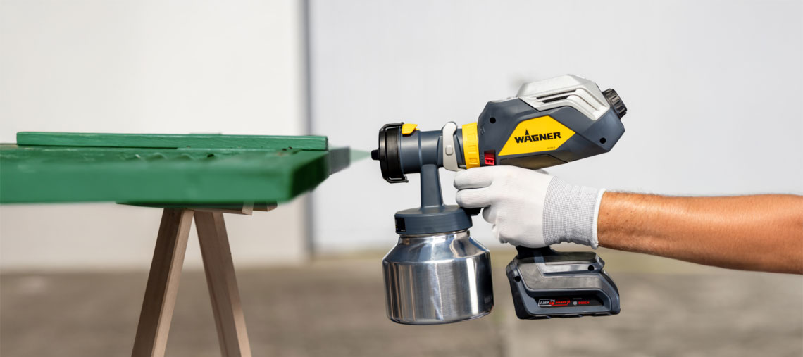 Zařízení na stříkání barev Wagner je drženo na zeleném stole.