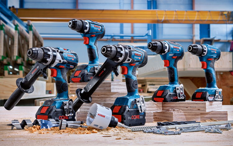 Several Bosch Professional cordless screwdrivers on wood with accessories.