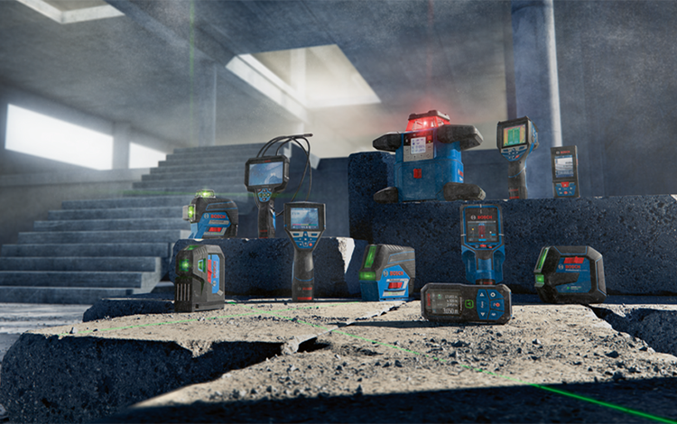 Several Bosch Professional measuring devices are placed on concrete blocks.