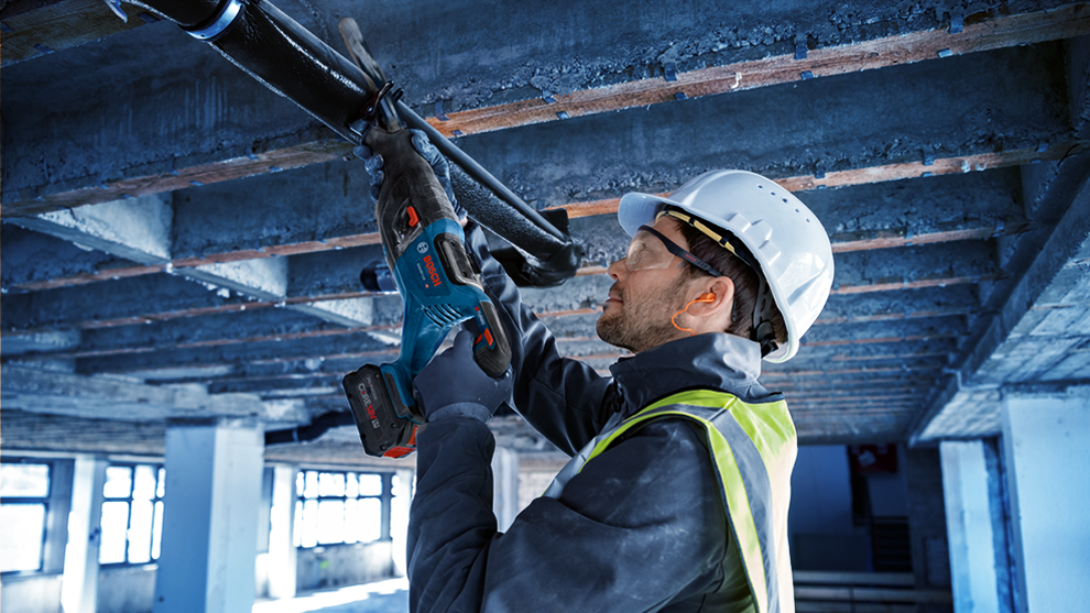 A worker with Bosch Professional tools stands under a concrete roof.