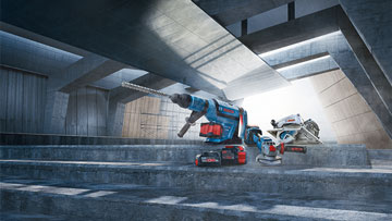 Синий сверло Bosch Professional на сером бетонном полу с игрой света.