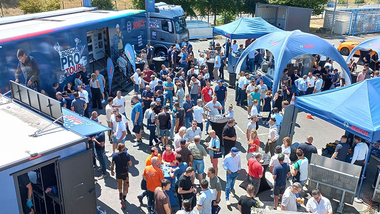 Eine große Menschenmenge versammelt sich um Foodstände und Zelte, um an einer Veranstaltung teilzunehmen.