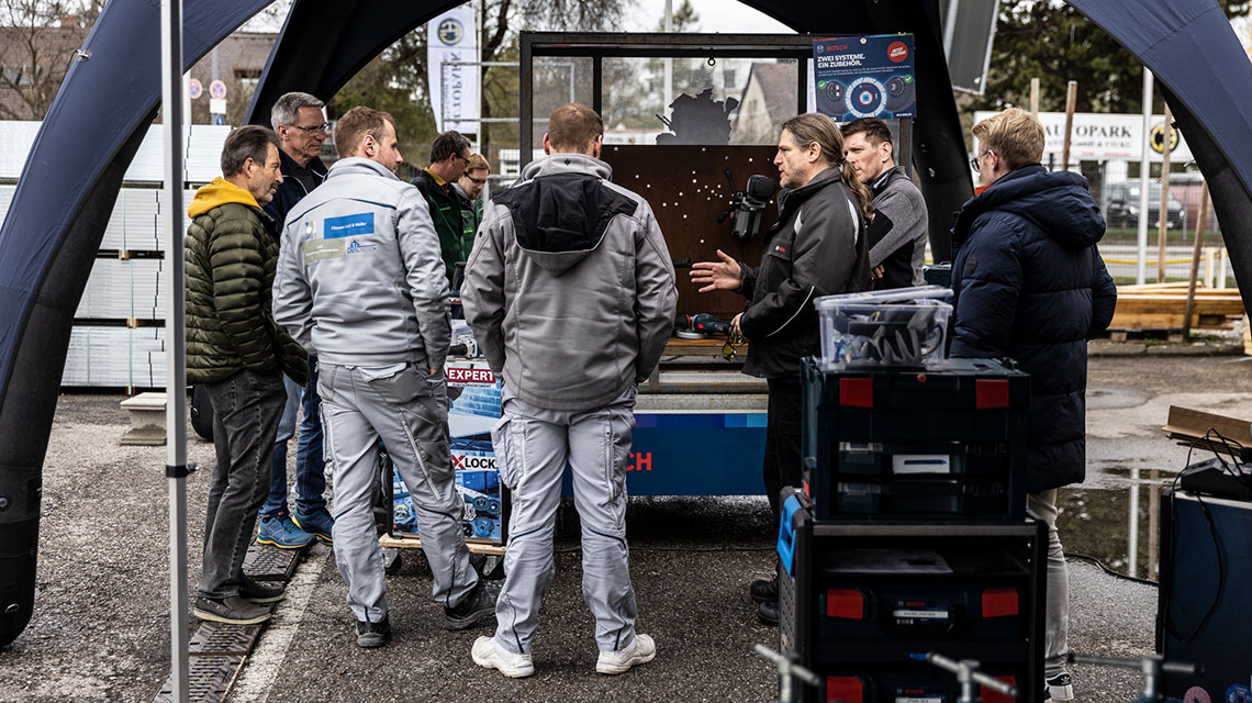 Flere personer står omkring et bord med Bosch værktøj.