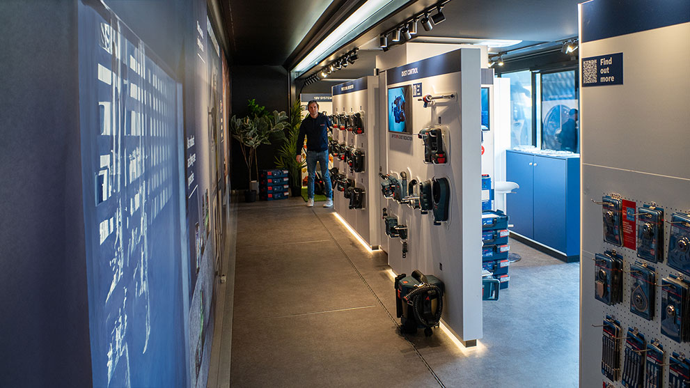 En mand står i en moderne værktøjsbutik med Bosch-produkter.