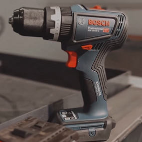 Un destornillador inalámbrico azul Bosch Professional está sobre un banco de trabajo.