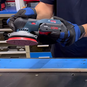 Una lijadora a batería Bosch Professional es sostenida por una persona.